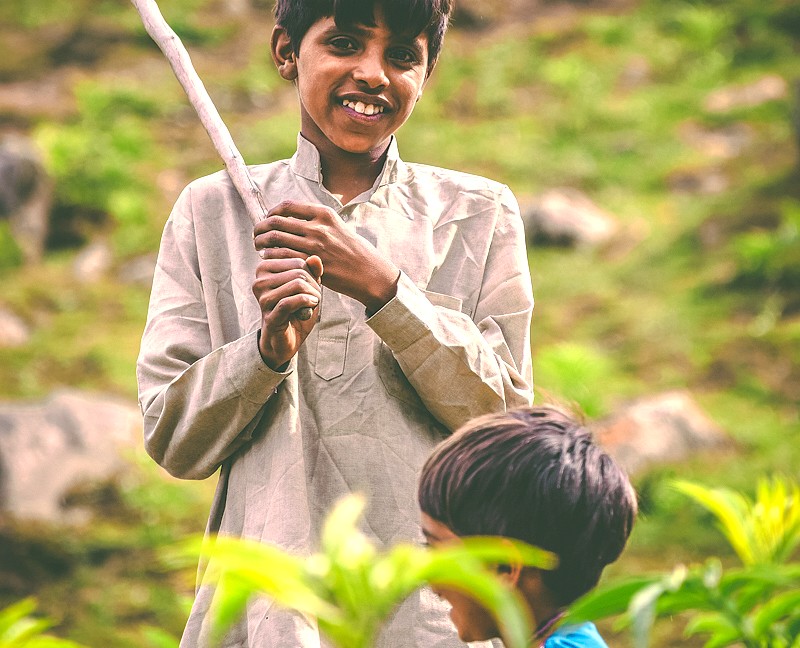 A smiling local boy plays near Nigeen Lake, a common sight on a Nehru Ghat shikara boat tour in Srinagar, Jammu and Kashmir, India.