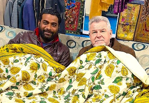 A tourist examines a traditional quilt with a local vendor, a stop on a Nehru Ghat shikara boat tour of Nigeen Lake in Srinagar, Jammu and Kashmir, In