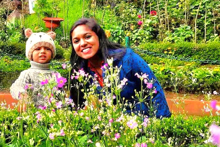 A mother and child's loving relationship blossoms amidst the colourful flowers of a botanical garden in Ooty, a popular destination for tourists exploring Kerala, India, near Munnar and the Unesco Western Ghats.