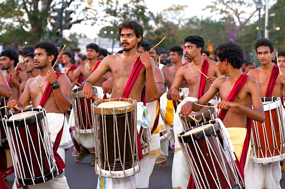 Young Tamil Nadu drummers performing at a vibrant Palani Hills festival in India, showcasing traditional attire, rhythmic community celebration, cultural heritage, outdoor procession, festive energy. Young Tamil Nadu drummers performing at a vibrant Palani Hills festival in India, showcasing traditional attire, rhythmic community celebration, cultural heritage, outdoor procession, festive energy.