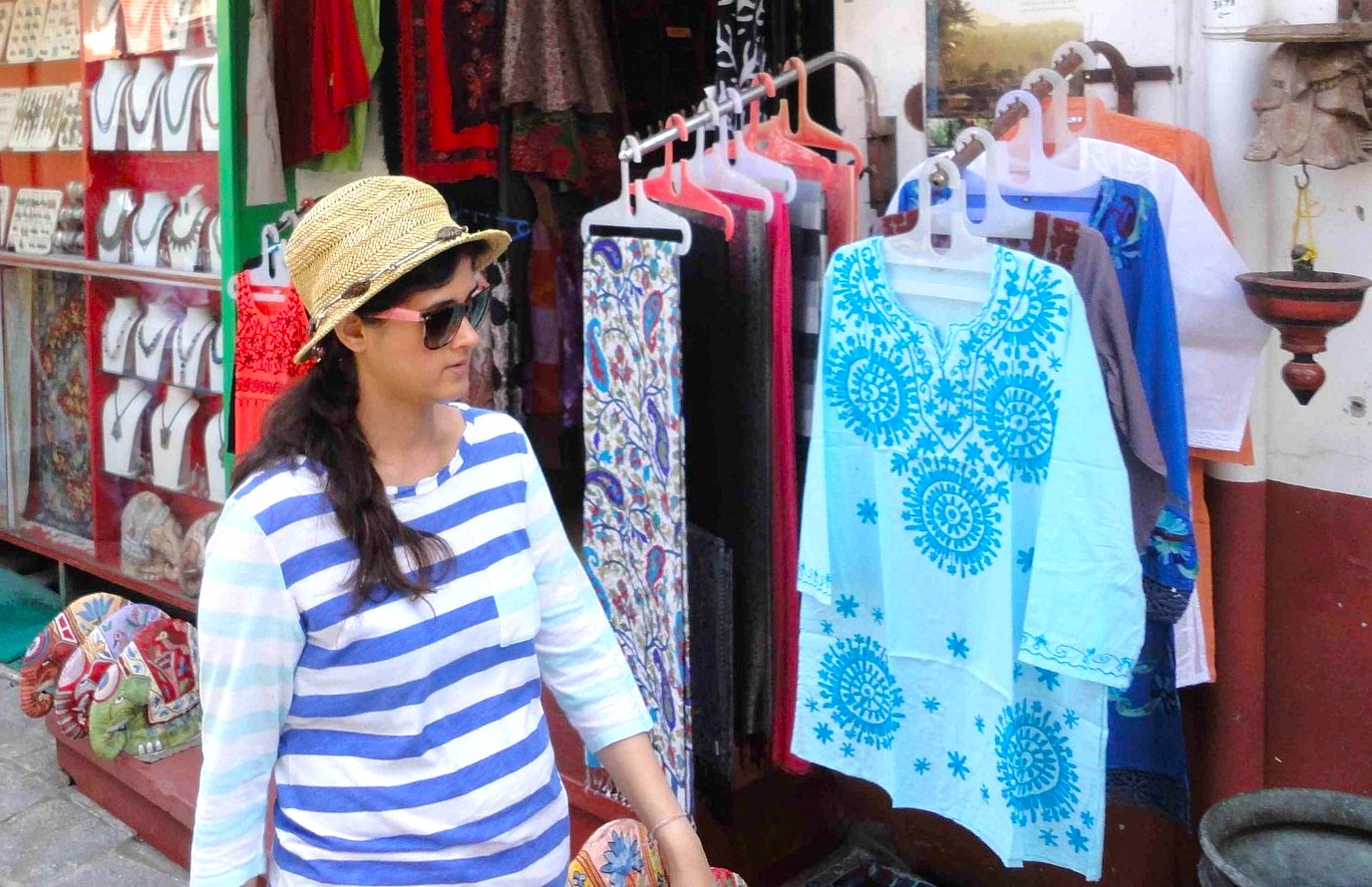 Woman exploring colorful artisanal textiles and accessories at a bustling outdoor market near the historic Paradesi Synagogue Kochi in South India, Kerala, showcasing vibrant local traditional fashion and cultural crafts. Woman exploring colorful artisanal textiles and accessories at a bustling outdoor market near the historic Paradesi Synagogue Kochi in South India, Kerala, showcasing vibrant local traditional fashion and cultural crafts.