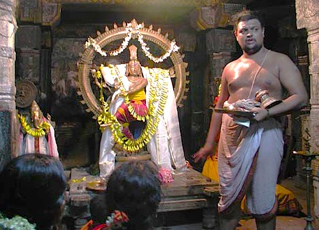 A Hindu priest performing puja to an adorned Shiva lingam at Patteeswara Temple in Coimbatore, Tamil Nadu, India, reinforcing heritage, worship, spiritual devotion, and tradition. A Hindu priest performing puja to an adorned Shiva lingam at Patteeswara Temple in Coimbatore, Tamil Nadu, India, reinforcing heritage, worship, spiritual devotion, and tradition.