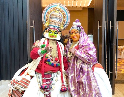 Two performers in vibrant traditional Kathakali costumes pose inside a cultural venue on Princess Street Kochi in South India, Kerala, showcasing performing arts heritage and local ceremonial artistry for visitors. Two performers in vibrant traditional Kathakali costumes pose inside a cultural venue on Princess Street Kochi in South India, Kerala, showcasing performing arts heritage and local ceremonial artistry for visitors.