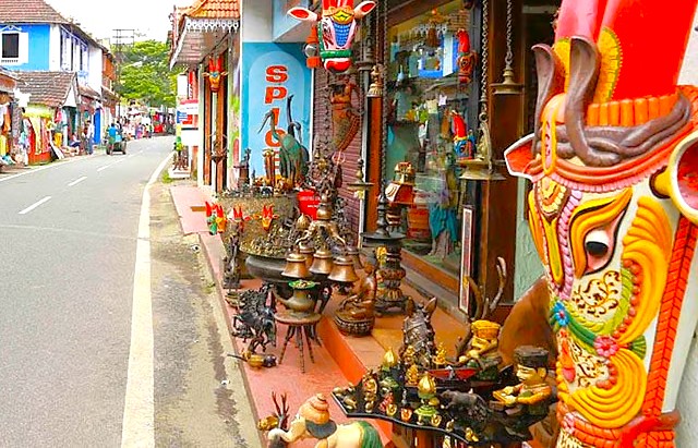 Vibrant marketplace displays colorful religious statues, brass lamps, traditional artifacts outside a bustling shop on Princess Street Kochi in South India, Kerala, inviting travelers to explore authentic handcrafts cultural treasures. Vibrant marketplace displays colorful religious statues, brass lamps, traditional artifacts outside a bustling shop on Princess Street Kochi in South India, Kerala, inviting travelers to explore authentic handcrafts cultural treasures.