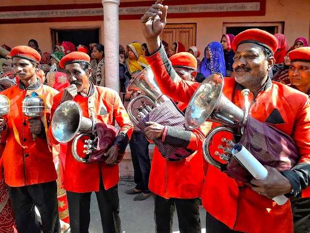 Brass musicians don vibrant red uniforms at Pushkar Ghats in Rajasthan, India, between Jaipur and Agra en route to the Taj Mahal, captivating visitors with lively energetic local band performances. Brass musicians don vibrant red uniforms at Pushkar Ghats in Rajasthan, India, between Jaipur and Agra en route to the Taj Mahal, captivating visitors with lively energetic local band performances.