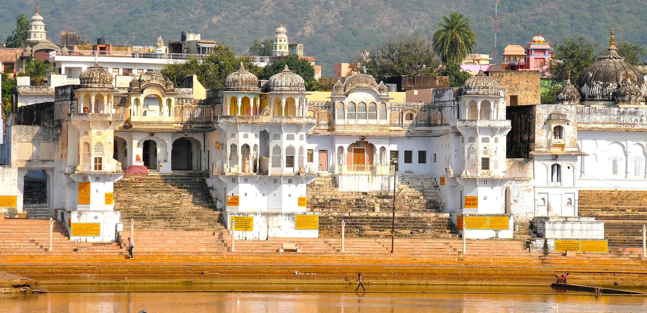 Temples and weathered stone ghats line Pushka Ghats lake in Rajasthan, India, framed by Aravalli hills, drawing pilgrims and photographers between Jaipur and Agra en route to the Taj Mahal. Temples and weathered stone ghats line Pushka Ghats lake in Rajasthan, India, framed by Aravalli hills, drawing pilgrims and photographers between Jaipur and Agra en route to the Taj Mahal.