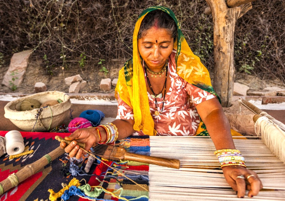 Artisan weaver at Pushkar Ghats in Rajasthan, India, creates colorful textiles on a loom by the ghats between Jaipur and Agra, showcasing craftsmanship on the way to the Taj Mahal. Artisan weaver at Pushkar Ghats in Rajasthan, India, creates colorful textiles on a loom by the ghats between Jaipur and Agra, showcasing craftsmanship on the way to the Taj Mahal.
