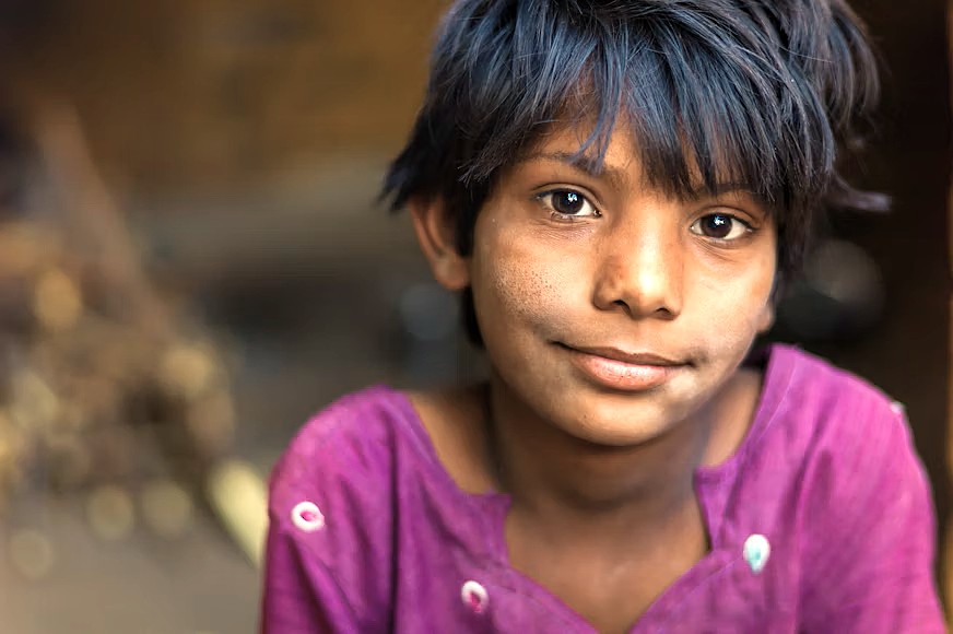 A portrait of a young local boy in Delhi, India, a glimpse of life near Unseco sites like Quttb Minar, Rajaon Ki Baoli in New Delhi, and the Red Foret.