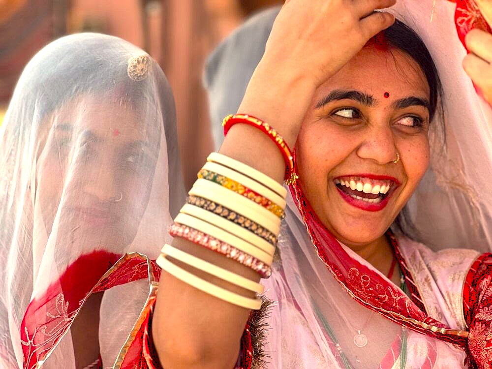 A candid photo captures smiling local women in vibrant traditional attire visiting the Qutb Minar in Delhi, India, a historic UNESCO site near the UNESCO Red Fort and UNESCO Humayun's Tomb. A candid photo captures smiling local women in vibrant traditional attire visiting the Qutb Minar in Delhi, India, a historic UNESCO site near the UNESCO Red Fort and UNESCO Humayun's Tomb.