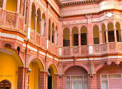 Elaborate ornate sandstone arches and lattice balconies of Rampura Havelis in Bikaner, Rajasthan, showcase traditional Rajasthani architecture and Thar Desert heritage, inviting historic immersive cultural exploration in vibrant northwestern India. Elaborate ornate sandstone arches and lattice balconies of Rampura Havelis in Bikaner, Rajasthan, showcase traditional Rajasthani architecture and Thar Desert heritage, inviting historic immersive cultural exploration in vibrant northwestern India.