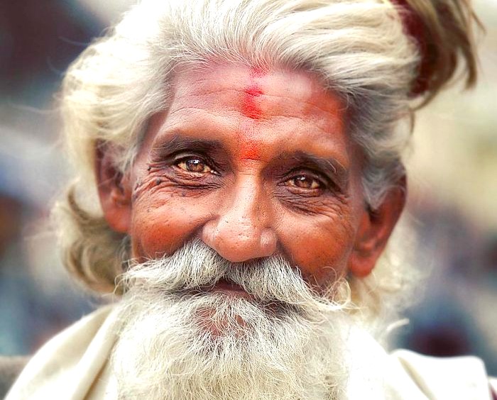 An elderly local villager with warm smile and traditional tilak stands near the Ranakpur Jain Temple in the Aravali Hills close to Jodhpur, Rajasthan, India, embodying cultural heritage and devotion. An elderly local villager with warm smile and traditional tilak stands near the Ranakpur Jain Temple in the Aravali Hills close to Jodhpur, Rajasthan, India, embodying cultural heritage and devotion.