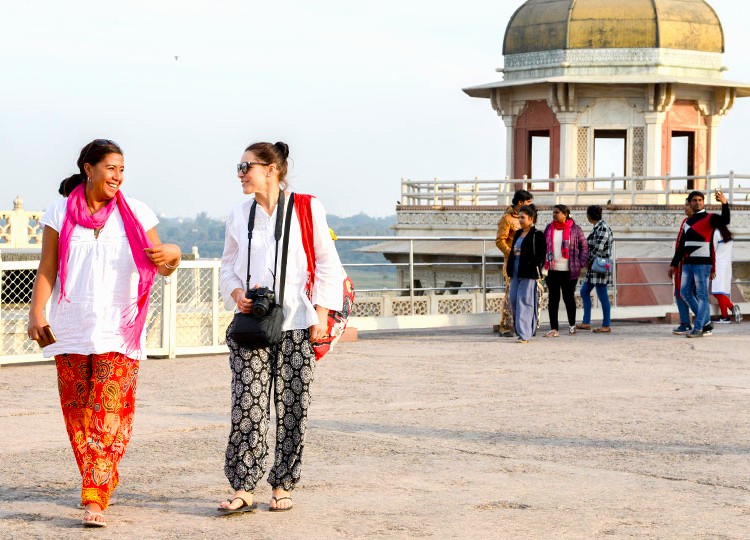 Two tourists stroll along the terrace of Ranakpur Jain Temple in the Aravali Hills near Jodhpur, Rajasthan, India, enjoying panoramic views, local craftsmanship, vibrant cultural atmosphere, and lush serene surroundings. Two tourists stroll along the terrace of Ranakpur Jain Temple in the Aravali Hills near Jodhpur, Rajasthan, India, enjoying panoramic views, local craftsmanship, vibrant cultural atmosphere, and lush serene surroundings.
