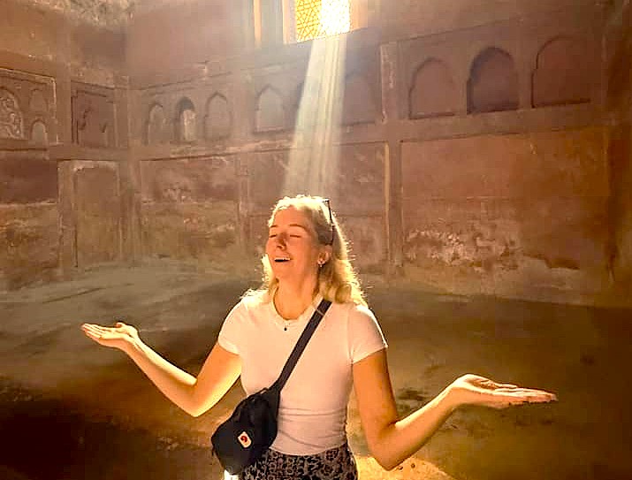 A tourist enjoys a spiritual moment in a beam of light inside the Ravana Pralad Cave Temple in Aihole, Karnataka, India, near Badami and the Pattadakal UNESCO site. A tourist enjoys a spiritual moment in a beam of light inside the Ravana Pralad Cave Temple in Aihole, Karnataka, India, near Badami and the Pattadakal UNESCO site.