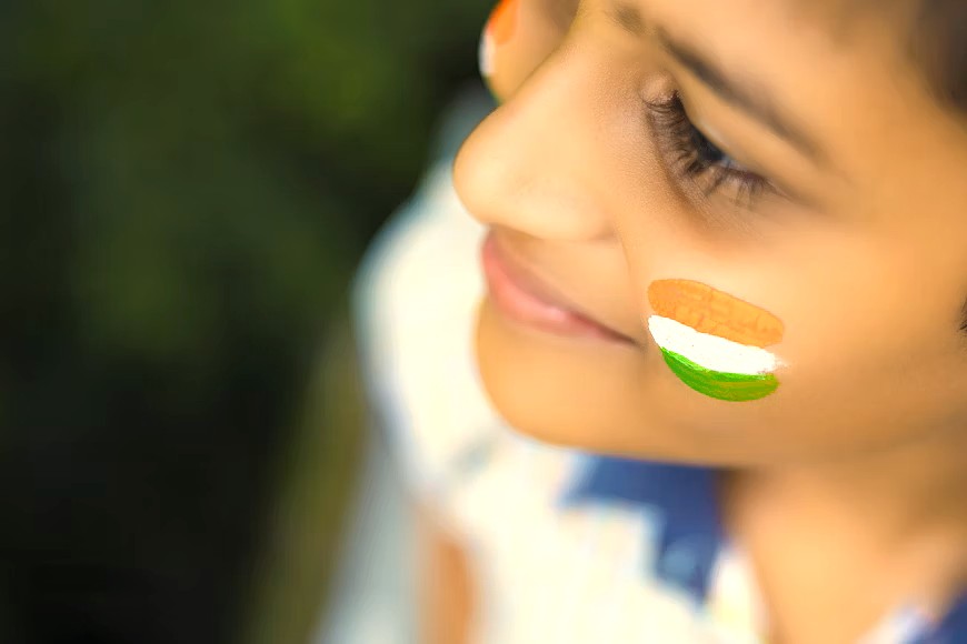 A child with India's flag painted on their cheek, celebrating near the Red Fort in Delhi-NCT, a UNESCO landmark associated with Humayun's Tomb and Qutb Minar. A child with India's flag painted on their cheek, celebrating near the Red Fort in Delhi-NCT, a UNESCO landmark associated with Humayun's Tomb and Qutb Minar.