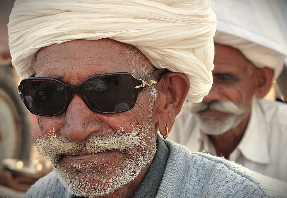 A close-up of an Indian man in a traditional white turban and sunglasses, a cultural sight for tourists visiting historic places like Se Cathedral in Old Goa, Goa, India.