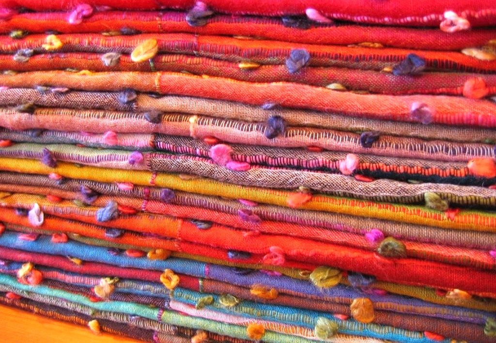 Handcrafted, vibrant fabric layers at Shalimar Weaves in Kodaikanal, Palani Hills, Tamil Nadu, South India, showcasing intricate weaving techniques, colorful pom-pom embellishments, and artisanal craftsmanship.