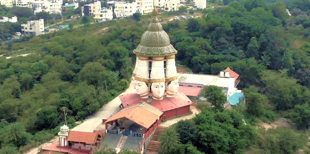 Aerial view of the three-faced Sanmukha Temple in Bangalore, Karnataka, India, near Mysore Palace, showcasing distinctive intricate carvings, serene surroundings, lush greenery, and blending traditional architecture into the vibrant landscape. Aerial view of the three-faced Sanmukha Temple in Bangalore, Karnataka, India, near Mysore Palace, showcasing distinctive intricate carvings, serene surroundings, lush greenery, and blending traditional architecture into the vibrant landscape.
