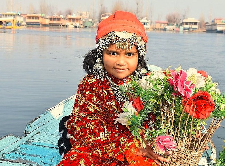 A Kashmiri girl in traditional dress on a shikara in Srinagar, Jammu and Kashmir, near Saffron feilds, ANU VALLY, BETTAB VAlly, and Chakau Arts Emporiem, famed for walnut wood art.