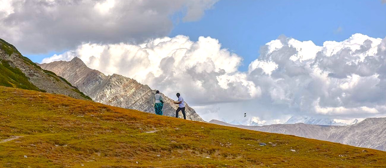 Hikers traverse the dramatic, high-altitude landscape of Sinthan Top in Kashmir-India, offering breathtaking Himalayas views, a stunning contrast to Srinagar, the UNESCO City of Arts.