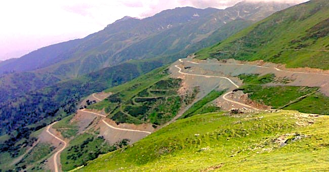 The winding, high-altitude mountain road leading to Sinthan Top showcases the rugged Himalayas landscape of Kashmir-India, a scenic drive from Srinagar, the UNESCO City of Arts. Sinthan Top
