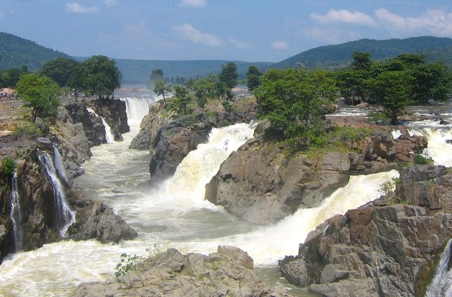 Scenic Pogenakkal waterfalls in South India cascade through rocky gorges amid lush greenery, majestic breathtaking natural wonder in region that includes Mysore, Hampi, Bangalore, Madurai.