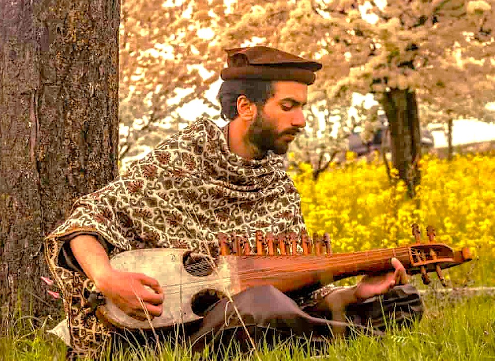 A Kashmiri musician plays a rabab in a field near Srinagar, Jammu and Kashmir, a region famous for Betaab Valley, Aru Valley, and its saffron fields. A Kashmiri musician plays a rabab in a field near Srinagar, Jammu and Kashmir, a region famous for Betaab Valley, Aru Valley, and its saffron fields.