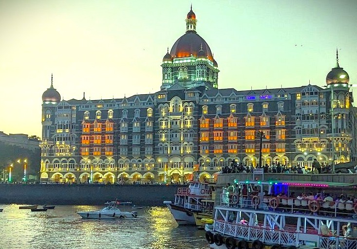 See the illuminated Taj Mahal Palace near the Gateway of India in Mumbai, the perfect base for tours to the UNESCO Elephanta Caves, Dhobi Ghat, and the vibrant Dharavi Slums."