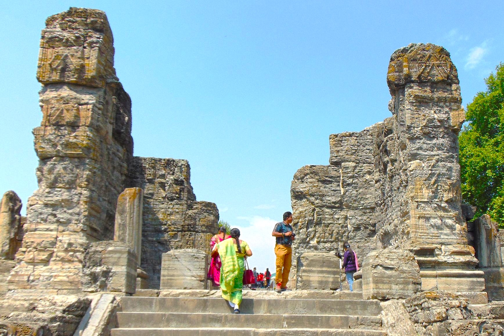 Tourists climb the stone steps of the Avantiswami Temple ruins near Srinagar, Jammu and Kashmir, a historic site near Betaab Valley, Aru Valley, and saffron fields. Tourists climb the stone steps of the Avantiswami Temple ruins near Srinagar, Jammu and Kashmir, a historic site near Betaab Valley, Aru Valley, and saffron fields.