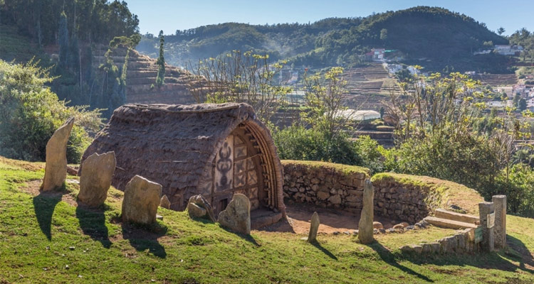 Traditional Toda hut with megalithic ritual stones set among rolling hills of Todi Village, Ooty, Tamil Nadu, Southern India, showcasing tribal architecture and natural serenity. Traditional Toda hut with megalithic ritual stones set among rolling hills of Todi Village, Ooty, Tamil Nadu, Southern India, showcasing tribal architecture and natural serenity.