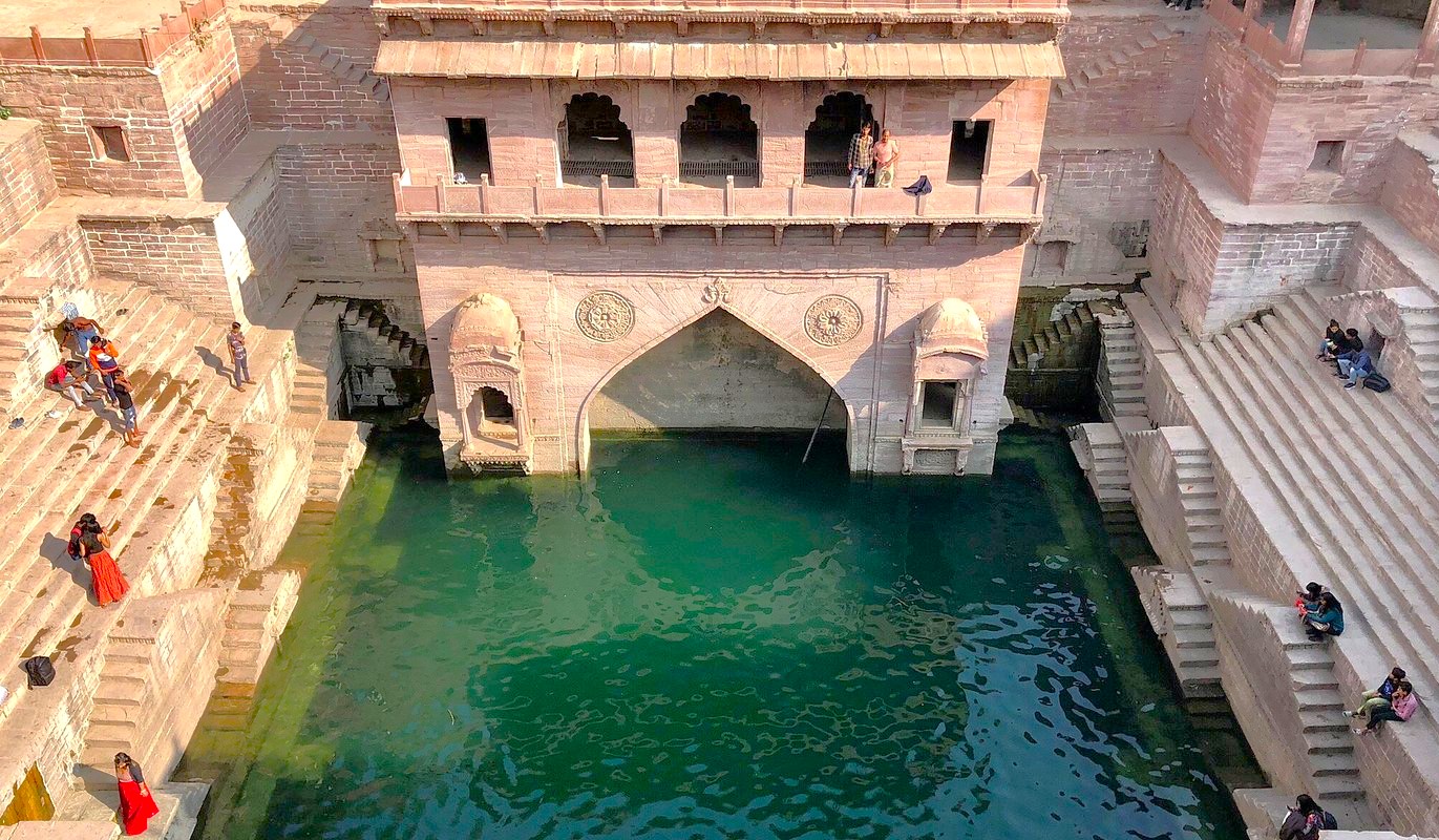 Tooji Ka Jhalra step well in Jodhpur, Rajasthan, India showcases striking Indo-Islamic architecture, intricate stone carvings, cascading steps, emerald water reservoir, cultural heritage tourism, and sustainable water management drawing travelers. Tooji Ka Jhalra step well in Jodhpur, Rajasthan, India showcases striking Indo-Islamic architecture, intricate stone carvings, cascading steps, emerald water reservoir, cultural heritage tourism, and sustainable water management drawing travelers.