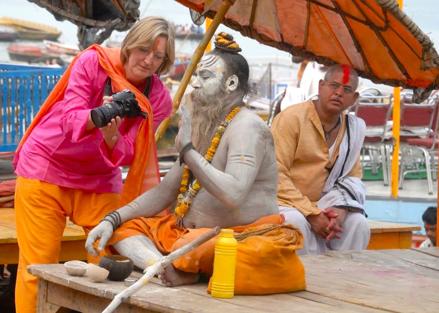 A tourist captures an ash-covered sadhu adorned with colorful marigold garlands and orange cloth at a Varanasi ghat, highlighting India’s spiritual heritage and inspiring journeys to Kerala, Munnar, Kochi, Mysore, Bangalore, Madurai, Delhi, Mumbai, Rajasthan. A tourist captures an ash-covered sadhu adorned with colorful marigold garlands and orange cloth at a Varanasi ghat, highlighting India’s spiritual heritage and inspiring journeys to Kerala, Munnar, Kochi, Mysore, Bangalore, Madurai, Delhi, Mumbai, Rajasthan.