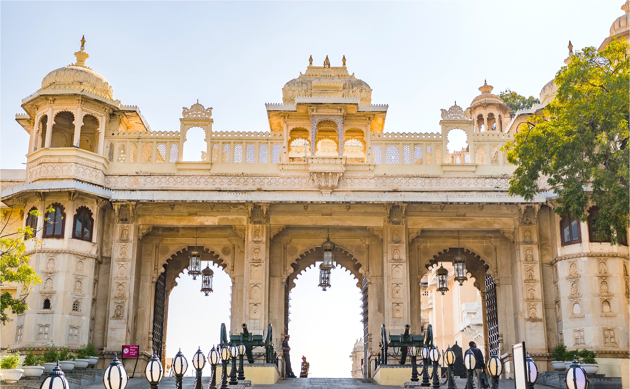 Grand carved entrance arches of Udaipur City Palace in Rajasthan, India, showcase majestic Rajput architecture, royal heritage, historic landmark appeal, intricate domes, ornate embellishments, cultural tourism magnet iconic design features. Grand carved entrance arches of Udaipur City Palace in Rajasthan, India, showcase majestic Rajput architecture, royal heritage, historic landmark appeal, intricate domes, ornate embellishments, cultural tourism magnet iconic design features.