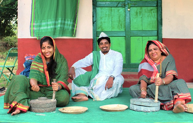 People in traditional Indian dress demonstrate using grinding stones at Utsav Rock Garden in Hubli, Karnataka, India, a cultural stop on a road trip near-Goa's Unesco Churches. People in traditional Indian dress demonstrate using grinding stones at Utsav Rock Garden in Hubli, Karnataka, India, a cultural stop on a road trip near-Goa's Unesco Churches.