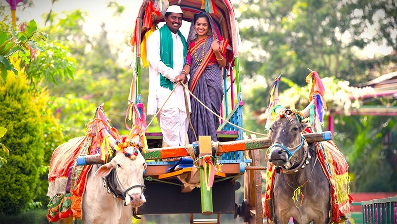 A couple in traditional dress enjoys a bullock cart ride at Utsav Rock Garden Hubli in Hubli, Karnataka, India, a perfect cultural stop on a road trip near-Goa's Unesco Churches. A couple in traditional dress enjoys a bullock cart ride at Utsav Rock Garden Hubli in Hubli, Karnataka, India, a perfect cultural stop on a road trip near-Goa's Unesco Churches.