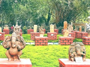 Within Bangalore's verdant sculpture garden in India, ancient stone Ganesha statues rest on distinctive red brick pedestals, revealing timeless artistic heritage. These outdoor exhibits beautifully highlight the rich cultural traditions, featuring meticulously crafted deities with intricate details that tell ancient stories. The famous Venkatappa Art Gallery extends beyond its gallery walls to this serene open-air collection. This unique setting provides a tranquil escape into art and nature for all.