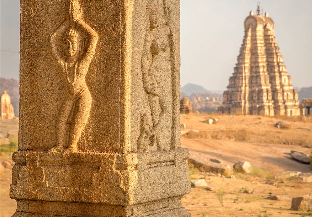 Intricate pillar carvings frame the Virupaksha Temple at the Hampi Unesco site in Karnataka, India, a vast complex that also includes the royal Elephant stables and queens baths.
