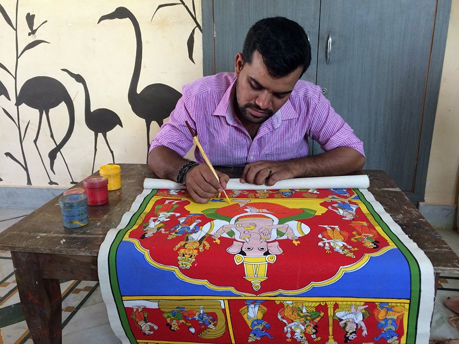  "Artist paints vibrant artwork in traditional style, showcasing southern india’s western ghats cultural heritage through intricate brushwork, rich colors, handcrafted techniques, and artisan dedication."