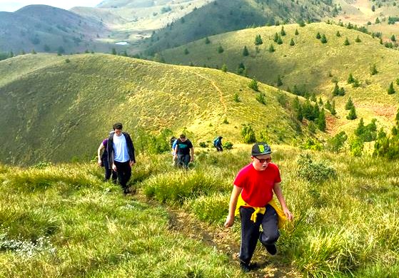 Group of hikers trekking lush trails through the Western Ghats in southern India, enjoying panoramic views, vibrant greenery, biodiversity, tranquil mountain landscapes on an adventure.