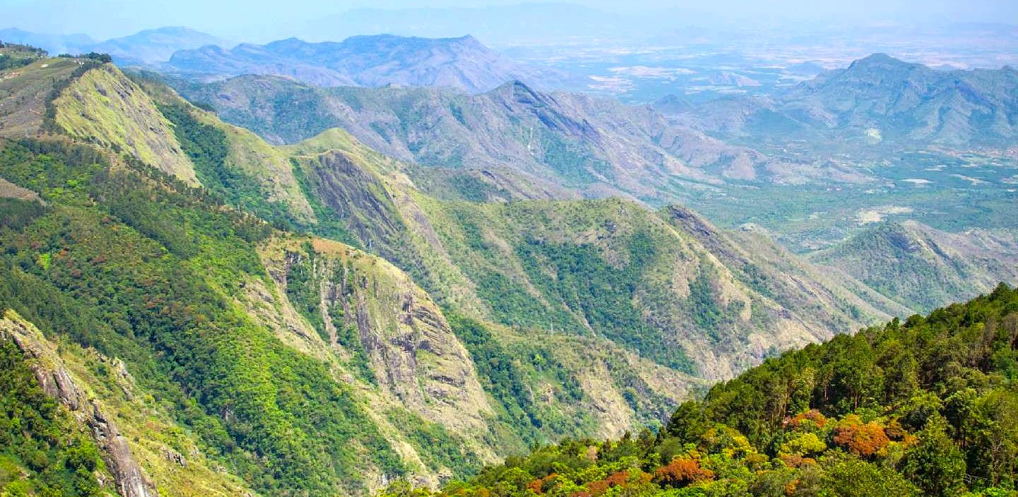  "Panoramic view of the western ghats in southern india, revealing verdant forested ridges, misty valleys, towering peaks and rich biodiversity, ideal for eco-tourism and trekking."
