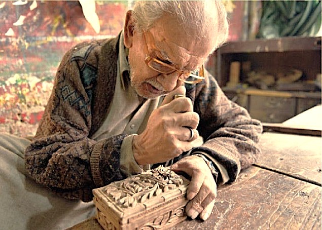 A Kashmiri artisan carves intricate walnut wood art at Chakau Arts Emporium in Srinagar, Jammu, near saffron fields, Aru Valley, and Betaab Valley.